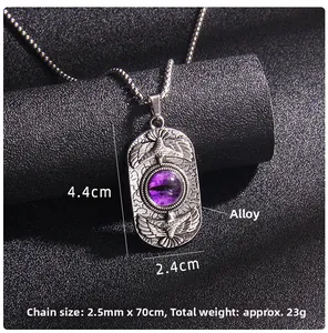 Detailed view of gothic steel pendant featuring a purple eye and double eagle engraving