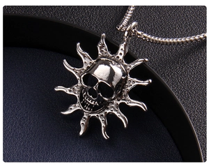 Macro shot of silver flame skull pendant necklace with gothic punk details and vintage finish