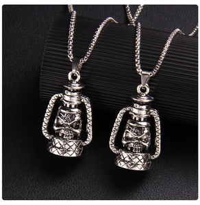Macro shot of silver gothic kerosene lamp pendants with detailed skull carvings