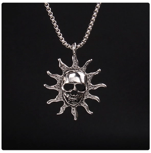 Close-up of silver stainless steel sun skull pendant with flame details on box chain