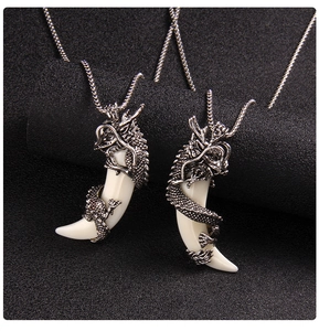 Detail of dragon-shaped wolf tooth pendants in silver finish with white resin accents