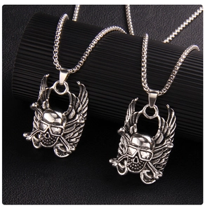 Macro view of punk style silver skull pendants with angel wings on steel box chains