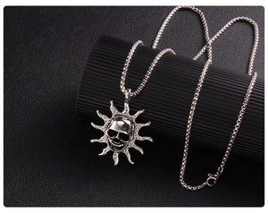 Macro shot of silver flame skull pendant with retro sunburst design on black base