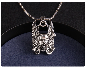 Macro shot of punk style skull pendant with wings and crossbones in vintage steel finish