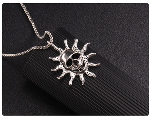 Macro shot of silver flame skull pendant with radiant sun rays on black leather