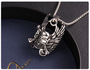 Close-up of punk gothic skull pendant with wings on a stainless steel snake chain