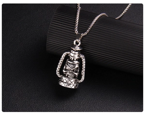 Macro shot of vintage silver skull oil lamp pendant on a punk box chain necklace