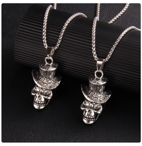 Détail du pendentif crâne avec chapeau haut de forme sur une chaîne box argentée