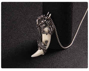 Macro view of detailed retro dragon wrapping ivory horn pendant on a metal chain