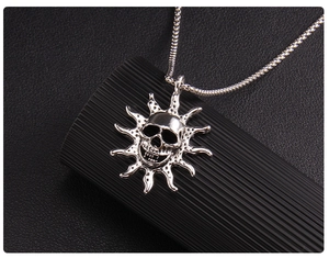 Macro shot of silver flame skull pendant with sunburst rays on black leather background