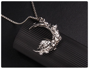 Détail du pendentif gothique lune et crâne avec texture de cratère sur un support noir