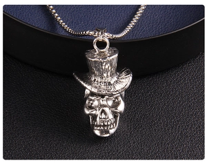 Vue détaillée du pendentif tête de mort avec chapeau sur chaîne en acier et cuir noir