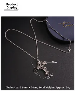 Detailed view of silver gothic cross pendant with coiled dragon on black texture