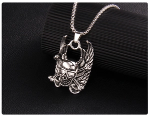 Close-up of gothic punk skull with angel wings pendant on a black box chain necklace