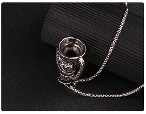 Macro view of vintage silver amphora pendant with embossed patterns and box chain