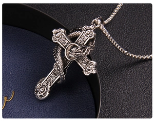Close-up of gothic stainless steel dragon cross pendant with intricate metal texture