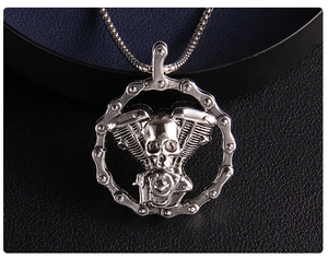 Macro shot of silver gothic skull pendant with motorcycle chain and engine details