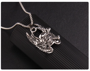 Detailed view of punk skull pendant with wings and crossbones on snake chain