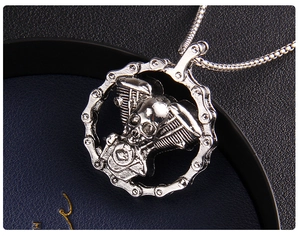 Macro shot of a gothic skull and motorcycle engine pendant with a heavy metal chain link
