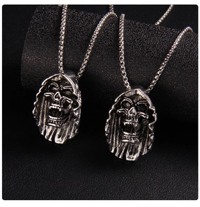 Detailed close-up of gothic grimace skull pendants with vintage silver finish and sturdy chains