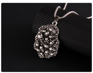 Détail macro du collier punk gothique avec pendentif tête de mort empilé et chaîne à mailles carrées