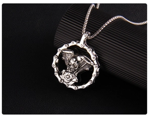 Close-up of gothic silver skull pendant with V-twin engine and biker chain ring