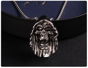 Macro detail of gothic skull pendant with vintage finish on dark textured jewelry box