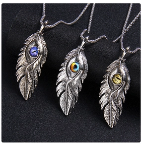 Détail des pendentifs plumes avec œil maléfique vintage sur support à bijoux
