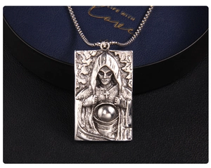 Détail macro du pendentif gothique en acier inoxydable avec relief de figure et chaîne box