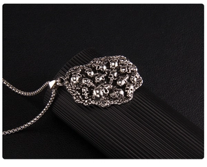 Détail macro du pendentif crâne punk gothique avec finition argentée et chaîne à mailles