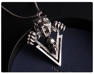 Détail macro du pendentif gothique tête de tigre et crâne sur chaîne boîte