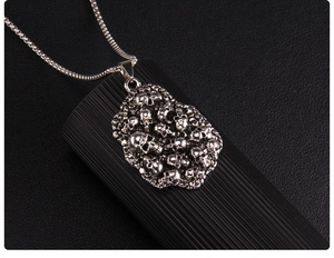 Détail du pendentif punk gothique avec crânes empilés et chaîne argentée