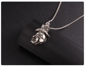 Détail du pendentif crâne gothique avec chapeau haut-de-forme sur une chaîne en métal