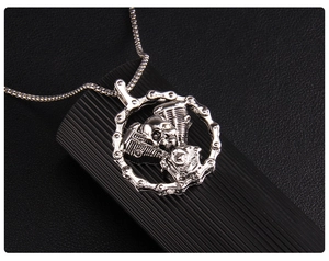 Macro shot of silver gothic skull pendant with motorcycle engine detail and square box chain