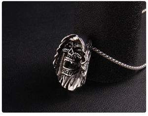 Macro shot of silver grim reaper skull pendant with detailed gothic metal texture