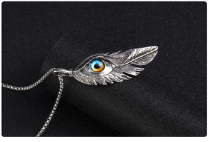 Vue macro d'un pendentif plume en acier inoxydable avec un œil maléfique bleu réaliste