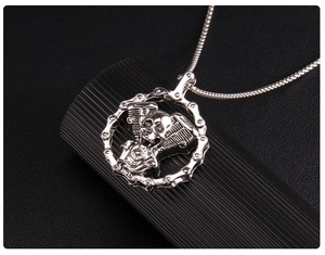 Detail of gothic skull necklace with V-twin engine and biker chain texture in silver