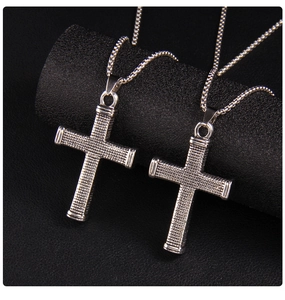 Macro view of vintage checkered cross pendant necklaces with detailed steel textures