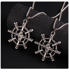 Detail shot of vintage stainless steel nautical anchor and ship helm pendant necklace