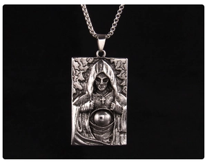 Gros plan du pendentif carré en argent vintage avec sorcier à capuche et croix