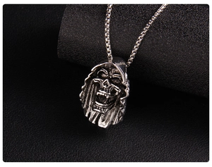 Close-up of gothic grim reaper skull pendant in vintage silver on a metal box chain