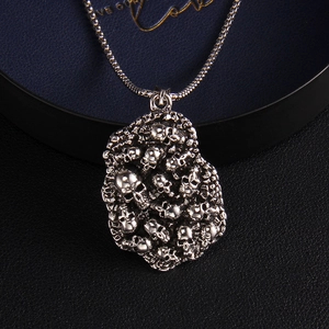 Collier gothique punk avec pendentif tête de mort irrégulier en métal sur fond sombre