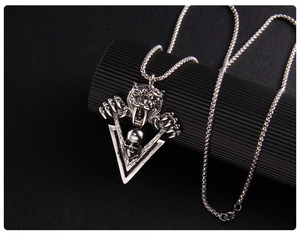 Gros plan détaillé du pendentif tigre et crâne de style punk sur un socle noir texturé