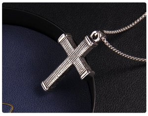 Macro shot of silver stainless steel cross pendant with checkered pattern and box chain