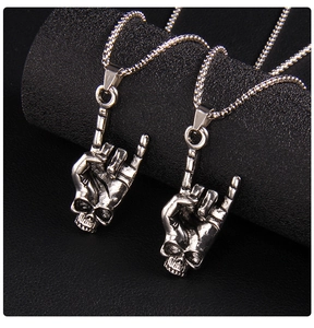 Macro shot of punk rock skeleton hand necklaces with realistic bone texture in vintage silver