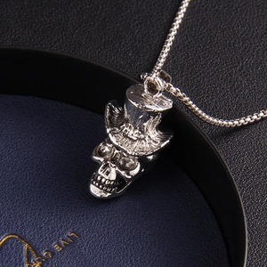 Collier hip hop pour homme avec pendentif tête de mort et chapeau sur fond bleu