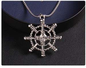 Close-up of vintage anchor helm pendant with star detail in a jewelry box