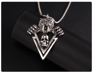 Détail du pendentif tête de tigre et crâne en acier inoxydable au fini argent vieilli