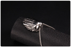 Macro shot of silver-toned punk skull pendant with radial texture and blackened finish