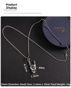 Detailed view of Gothic skull hand gesture pendant on black leather texture background
